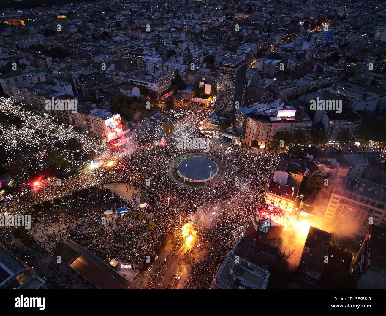 People shine the lights of they mobile phones and light flares during ...