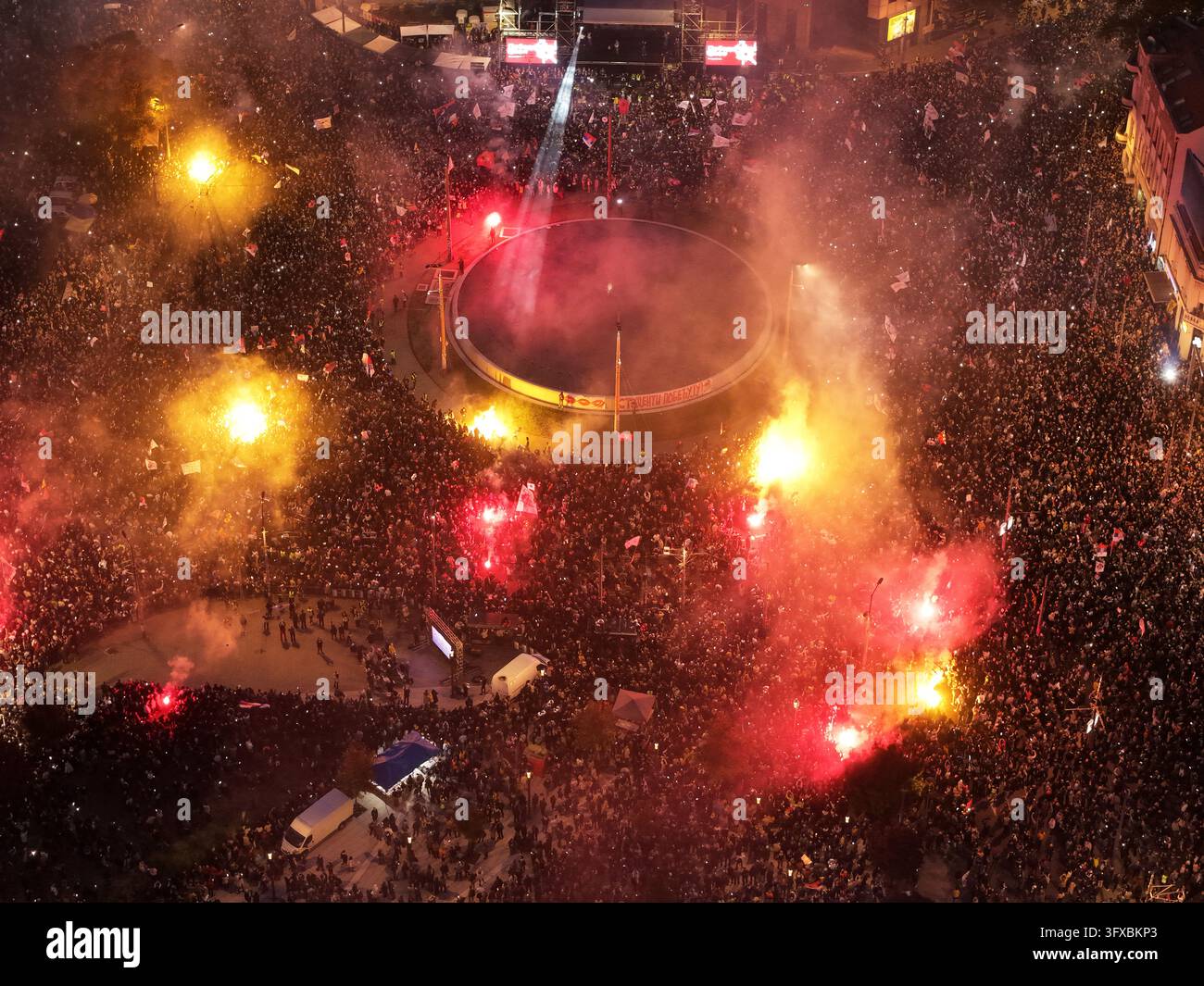 People shine the lights of their mobile phones and light flares during ...