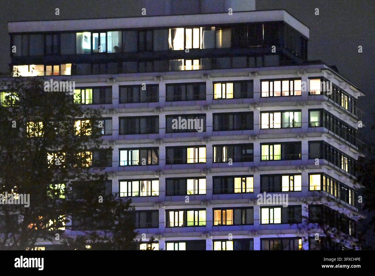 Beleuchtete Fenster eines Wohnhochhauses bei Nacht im Olympischen Dorf ...