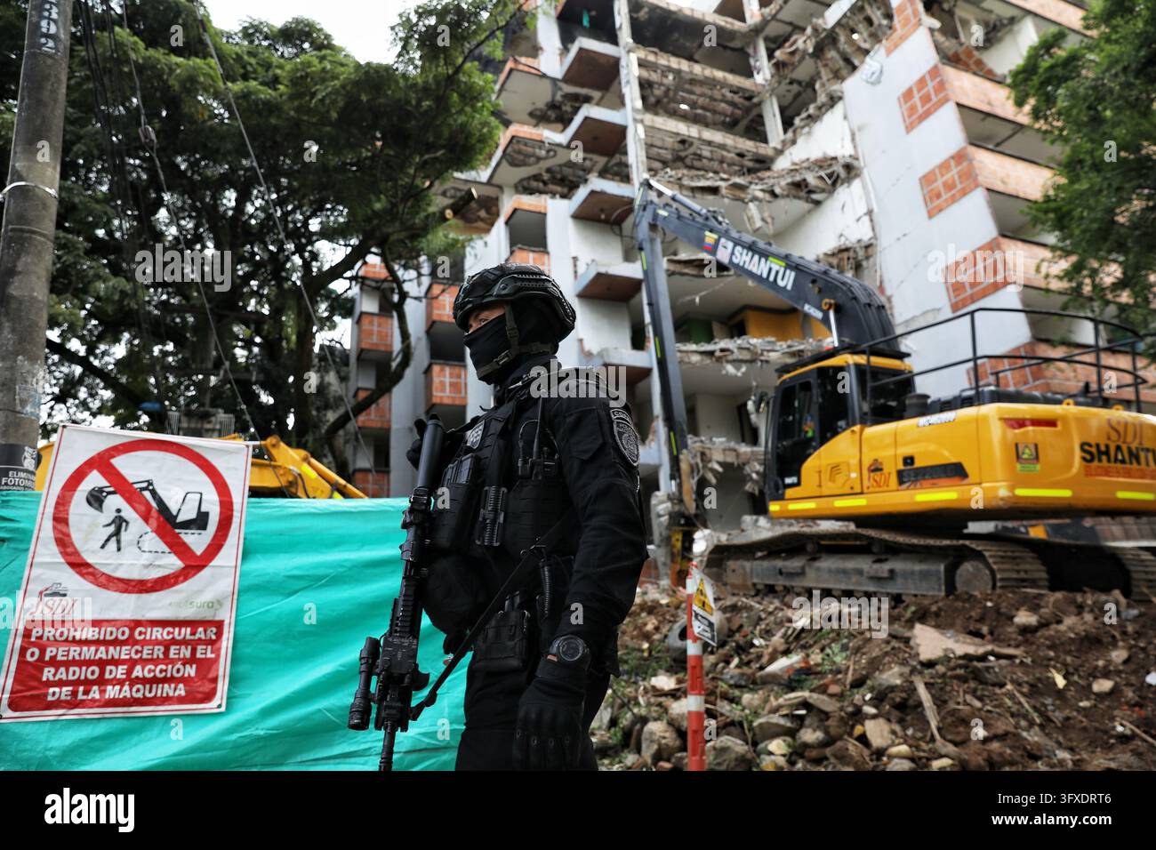 Trafficker A police officer stands guard at the demolition of a building once ...