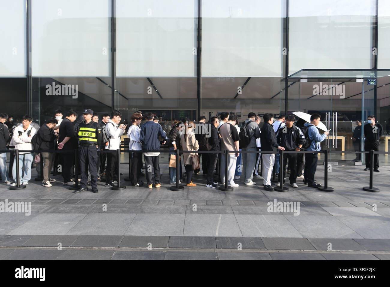 People line up to buy iPhone Duo handsets at an Apple Store in Hangzhou ...