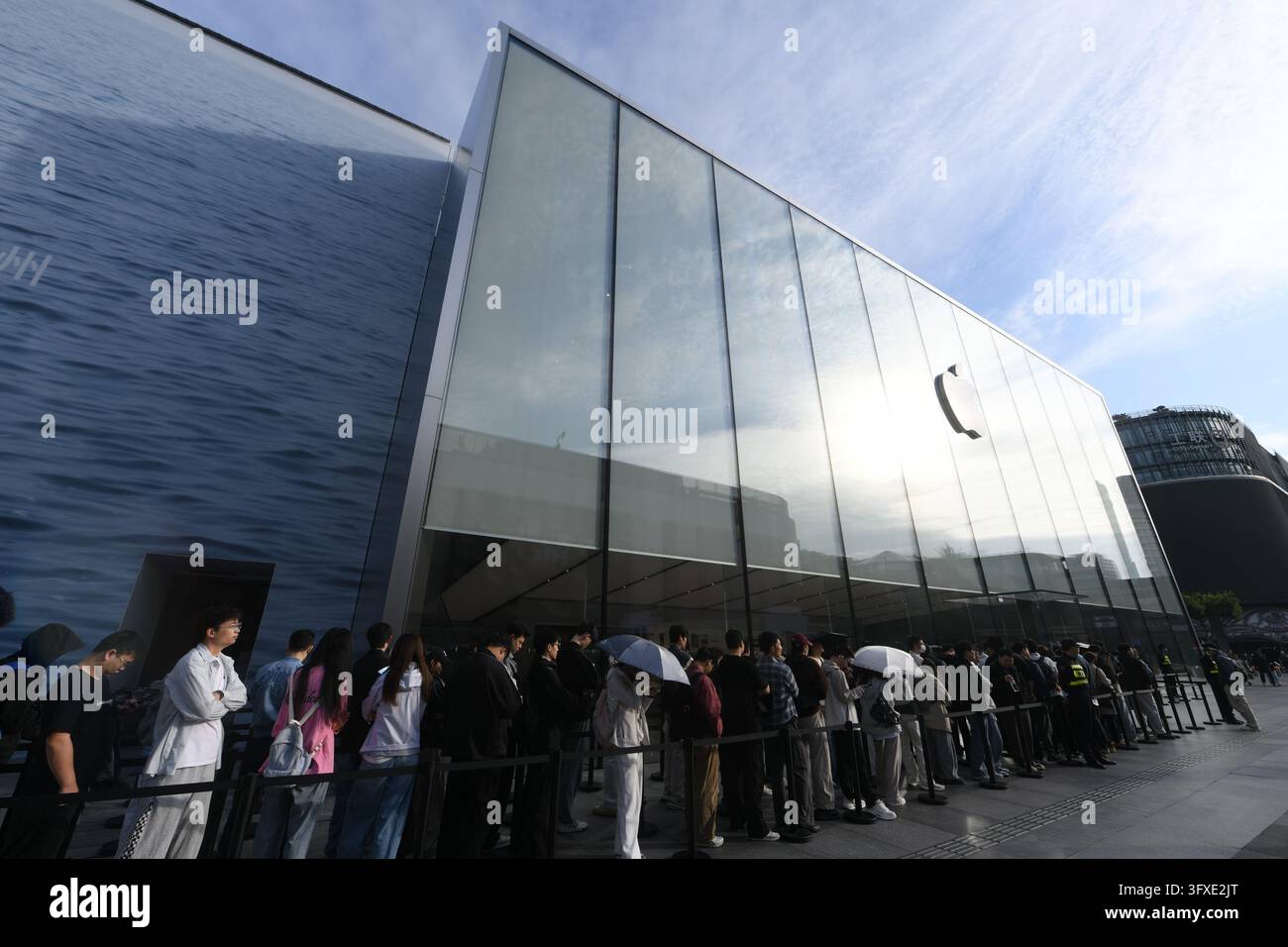 People line up to buy iPhone Duo handsets at an Apple Store in Hangzhou ...