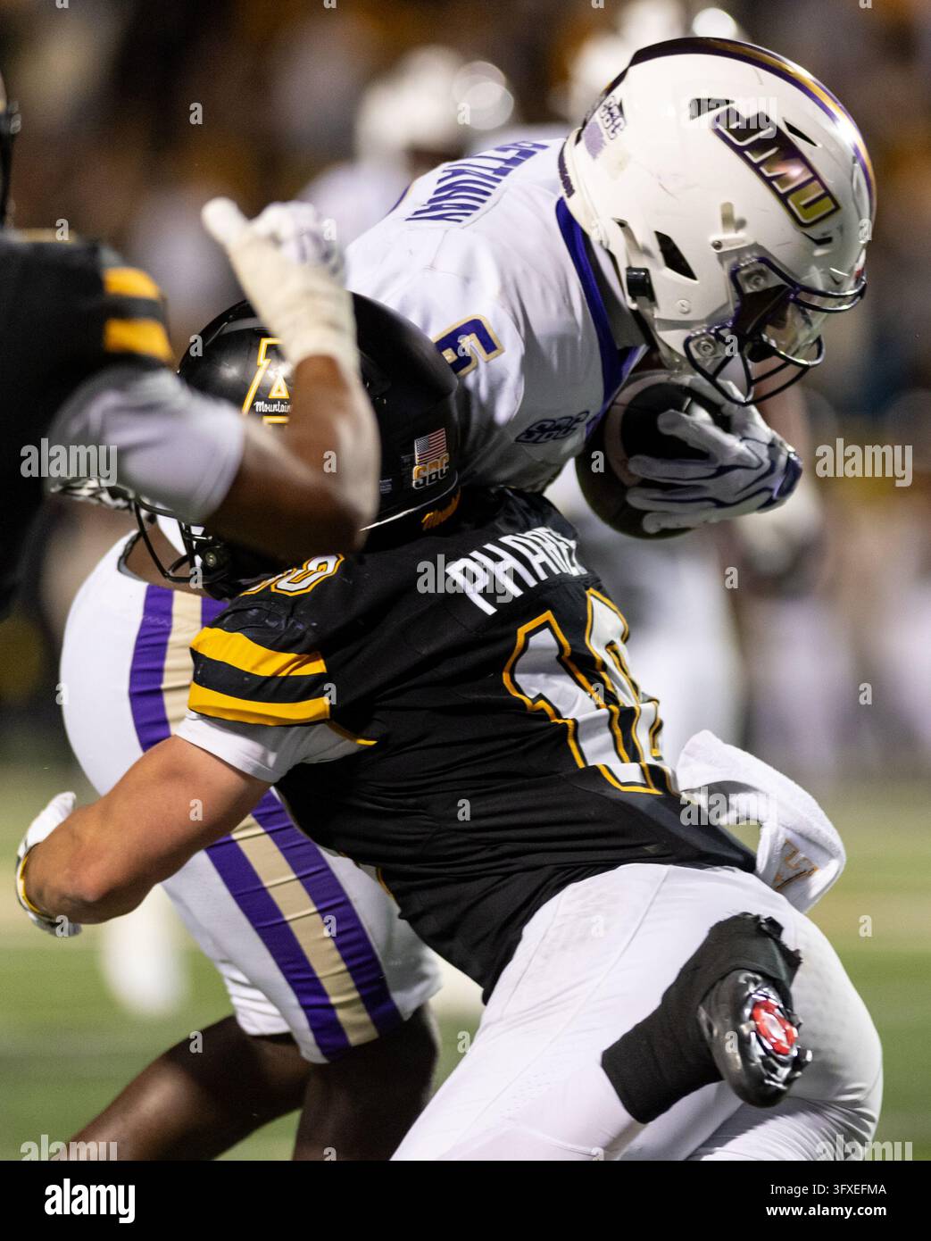 James Madison running back George Pettaway (6) is wrapped up by ...