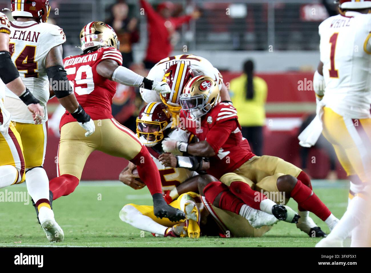 Washington Commanders quarterback Jayden Daniels (5) is brought down by ...