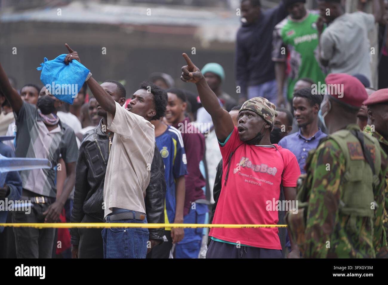 People watch from behind a security cordon after a multi-story building ...