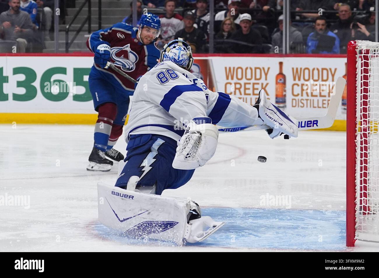 Puck Back Colorado Avalanche defenseman Devon Toews, back, shoots the puck past ...