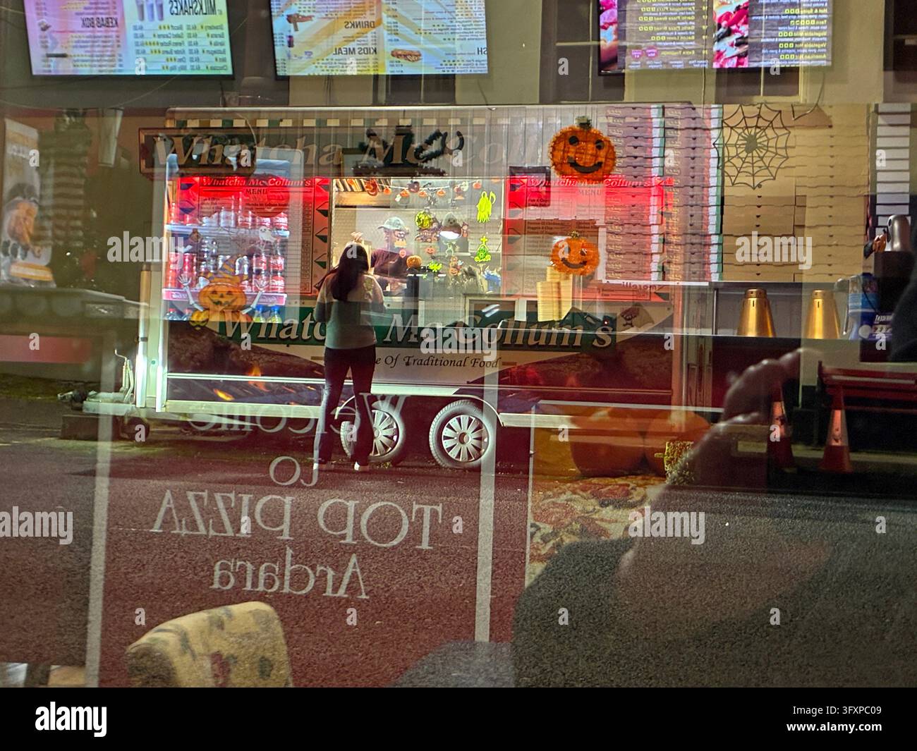 Fast food takeaway outlets reflections at night. - Smartphone Captured Stock Image