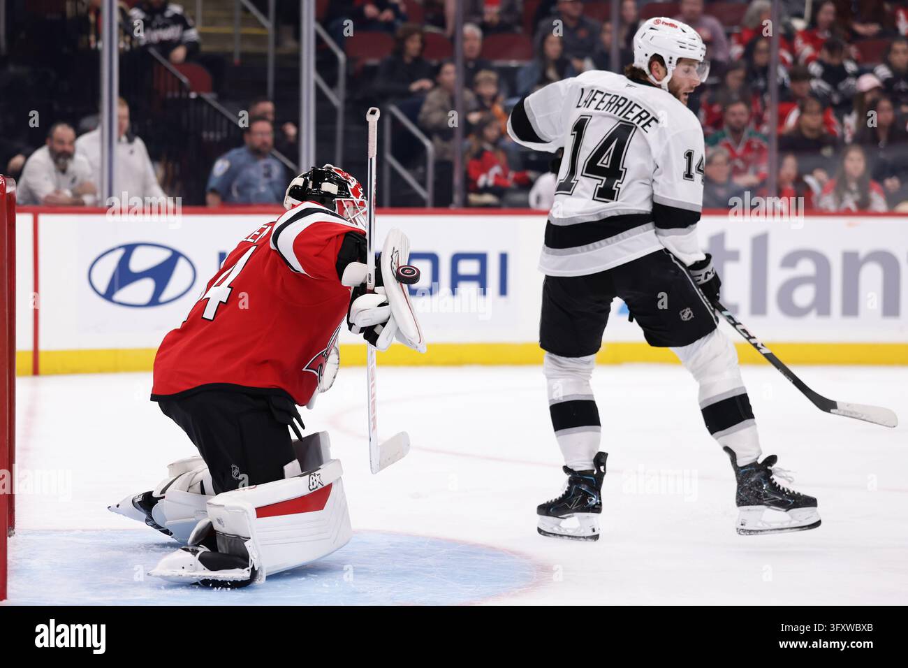 New Jersey Devils goaltender Jake Allen makes a save behind Los Angeles ...