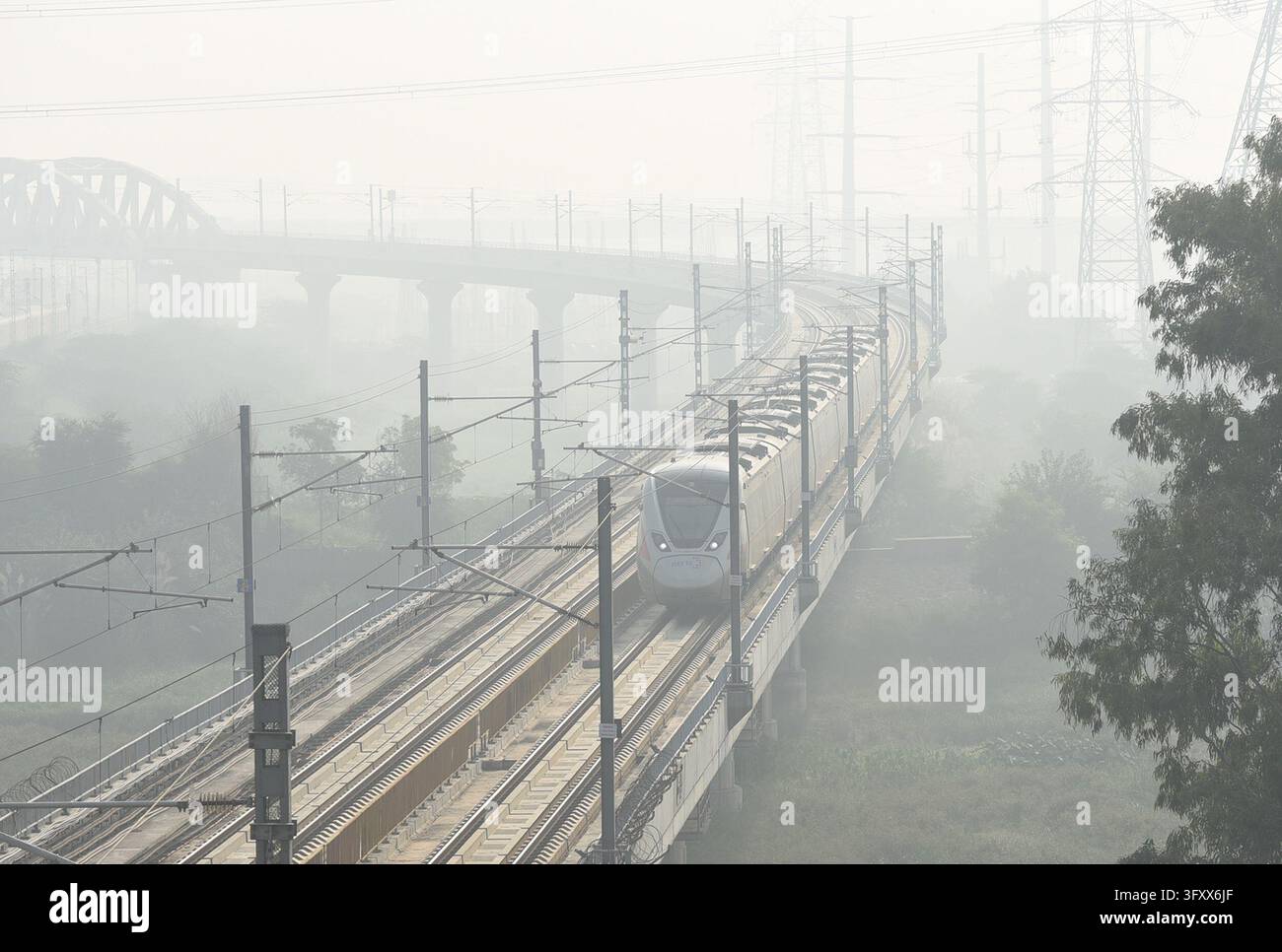 GHAZIABAD, INDIA - OCTOBER 23: A Rapid Rail train emerges through heavy ...