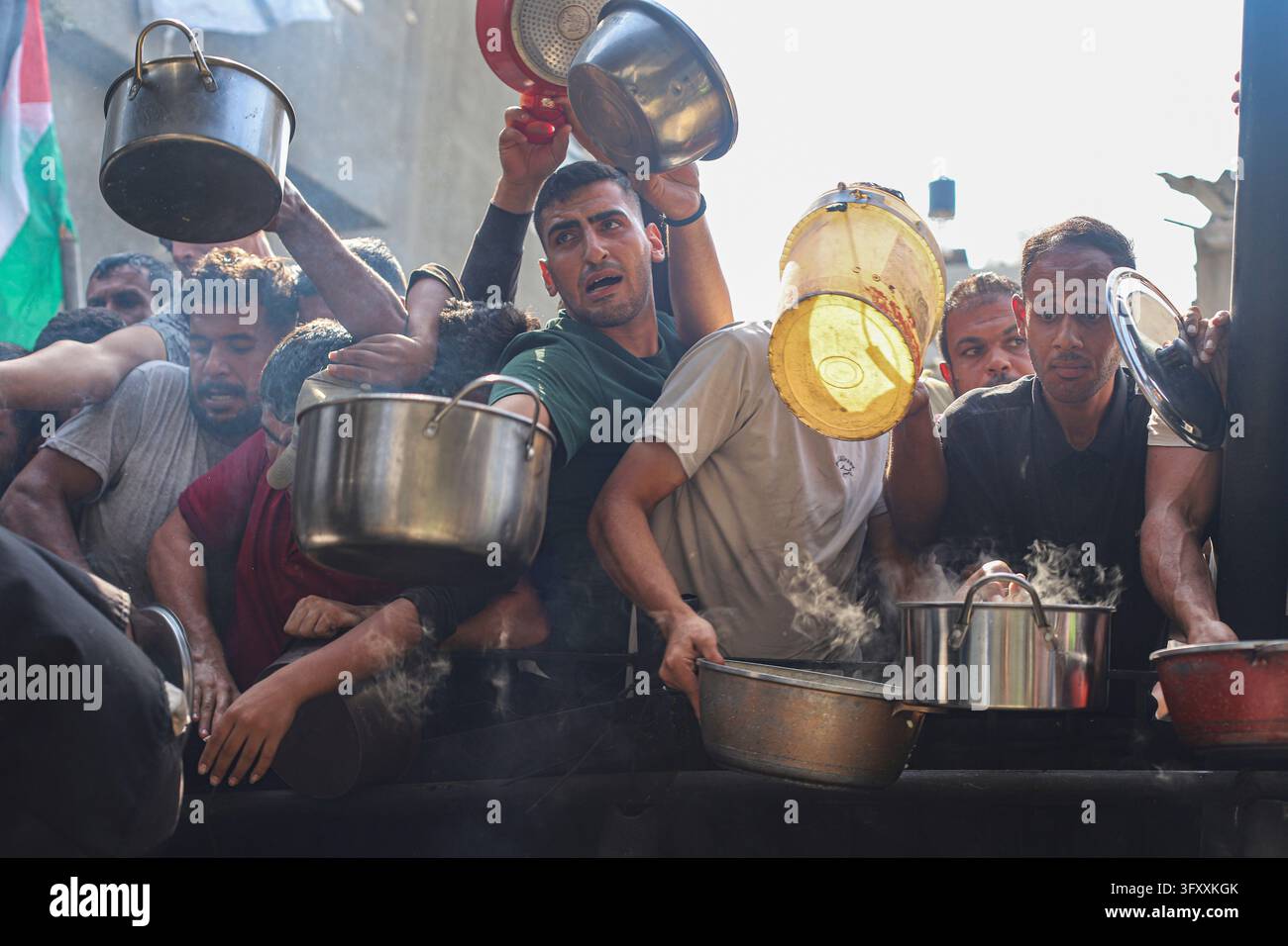 Palestinians press toward a charity kitchen carrying pots and bowls to ...
