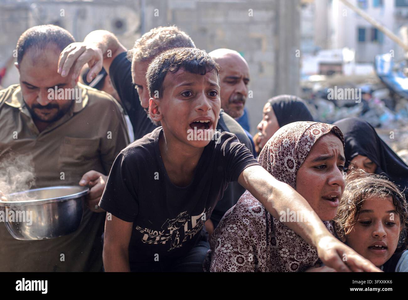 Palestinians press toward a charity kitchen carrying pots and bowls to ...