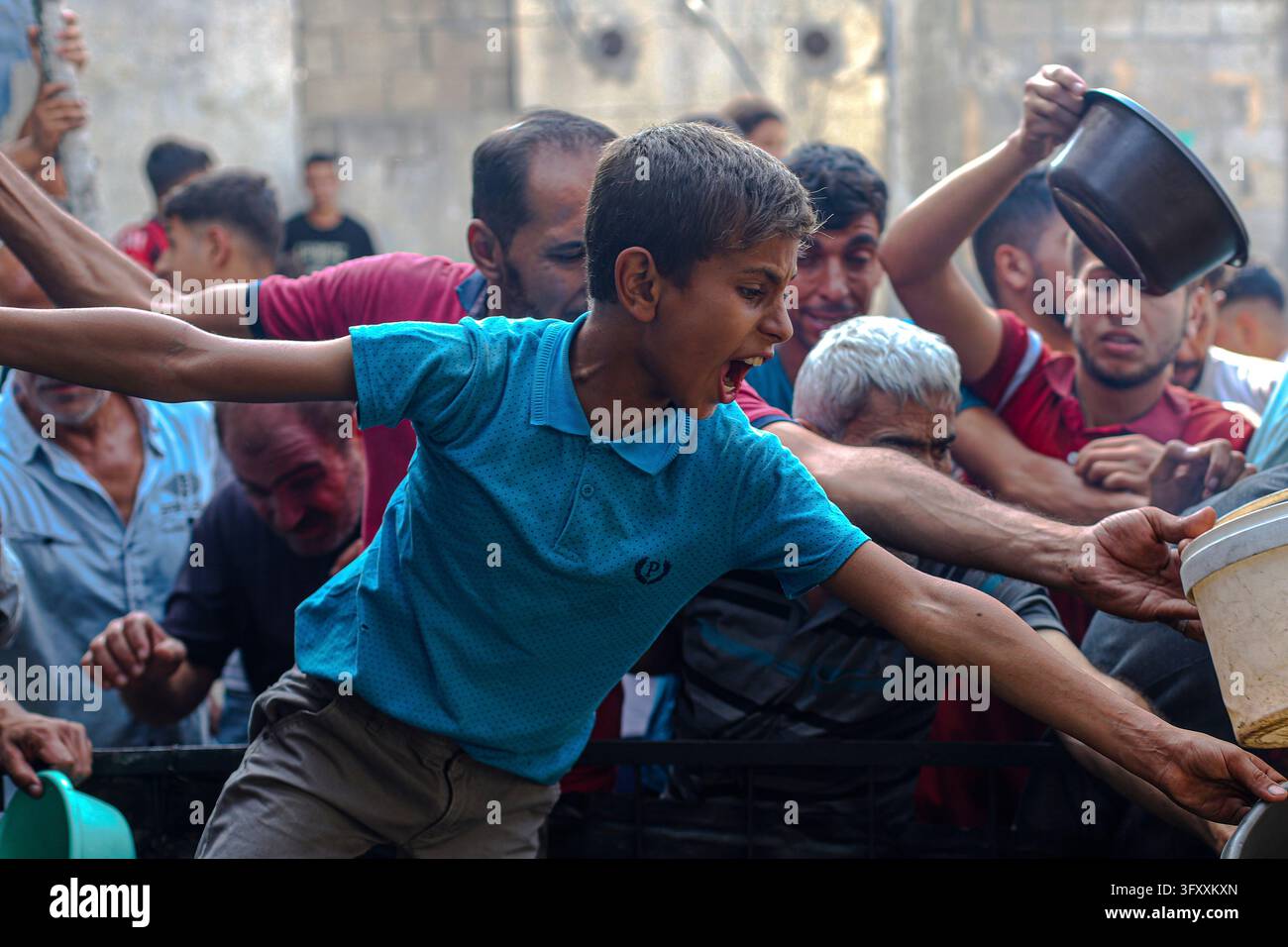 Palestinians press toward a charity kitchen carrying pots and bowls to ...