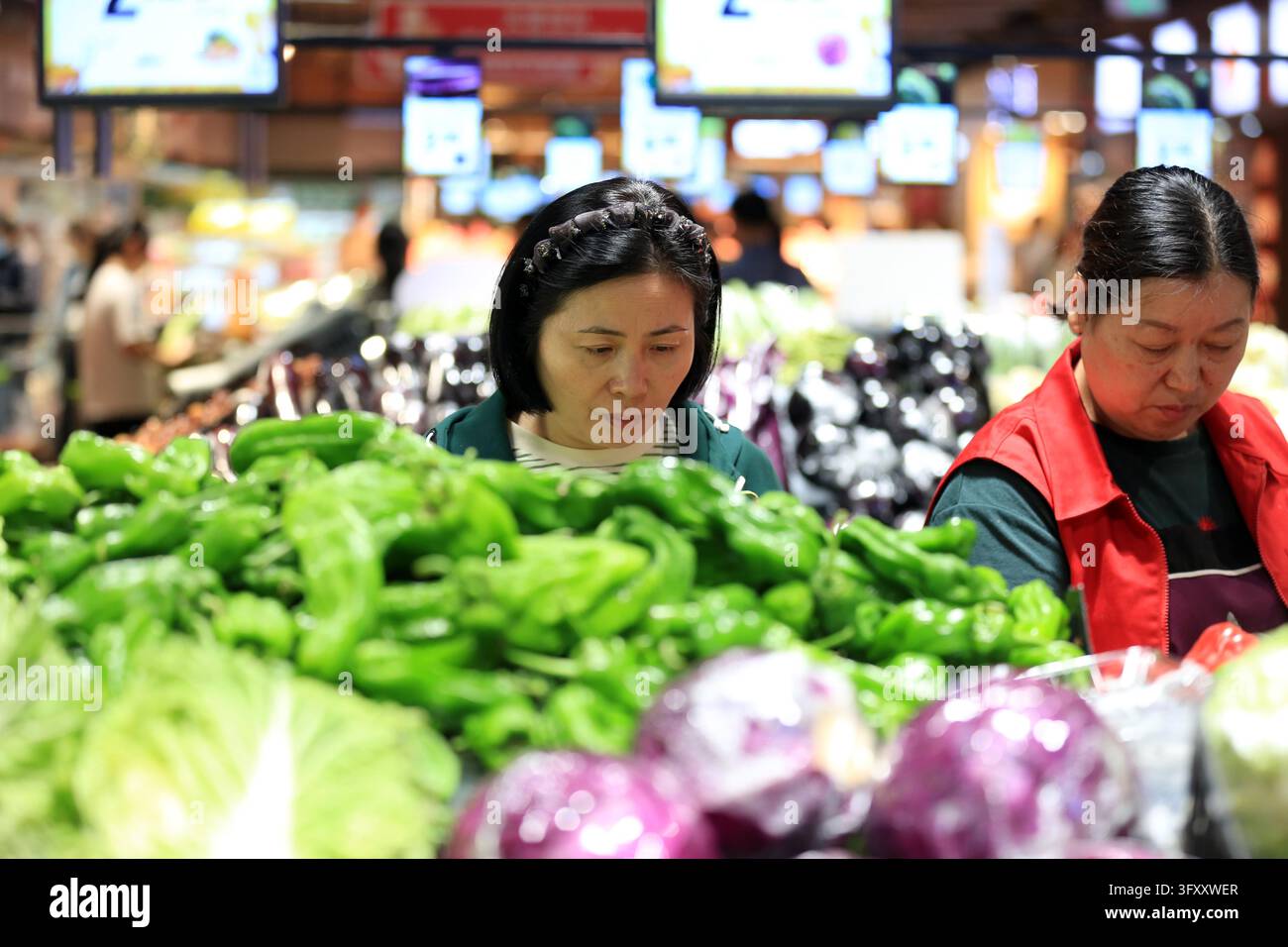 A shopper buys goods at a supermarket in Huai'an, east China's Jiangsu ...