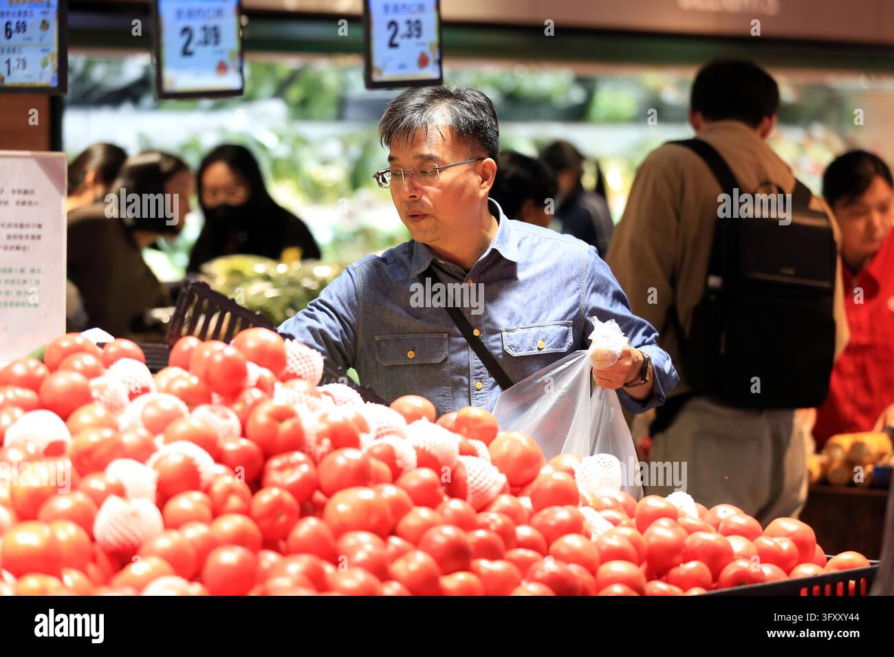 A shopper buys goods at a supermarket in Huai'an, east China's Jiangsu ...