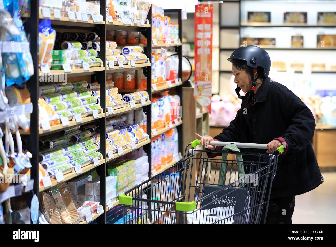 A shopper selects goods at a supermarket in Huai'an, east China's ...