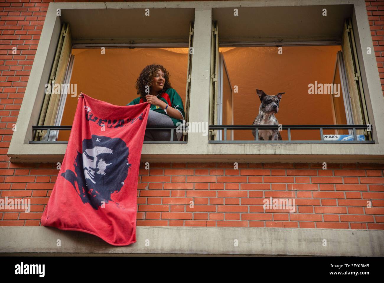 A resident displays a cloth bearing a portrait of Che Guevara from a