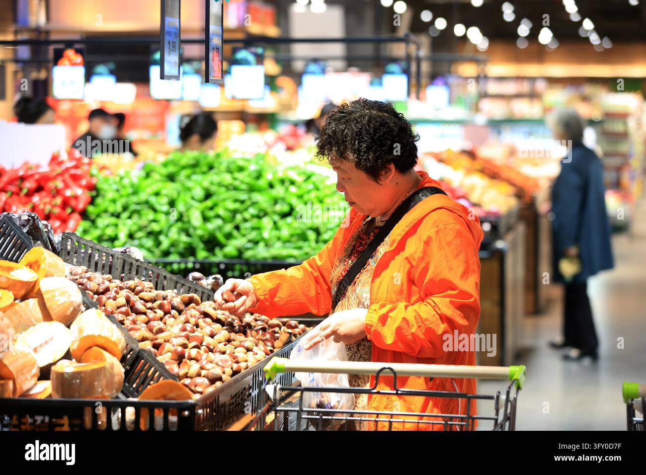 A shopper buys goods at a supermarket in Huai'an, east China's Jiangsu ...