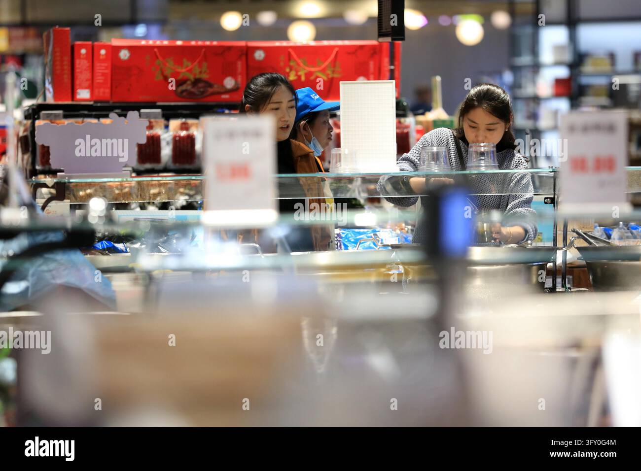 A shopper buys goods at a supermarket in Huai'an, east China's Jiangsu ...
