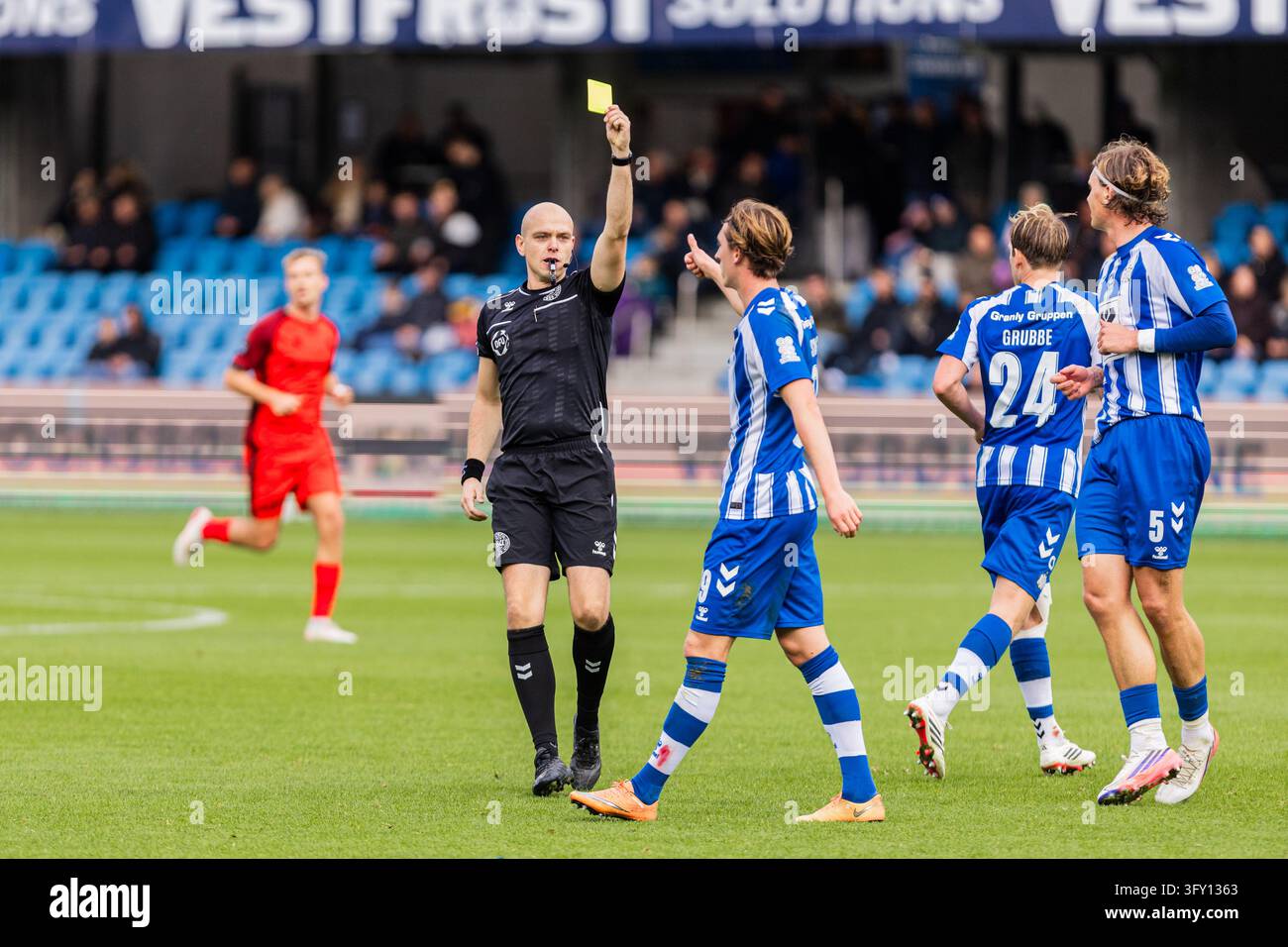 Strandby Esbjerg, Denmark. 24th, October 2026. Referee Jonas Bogelund books Noah ...