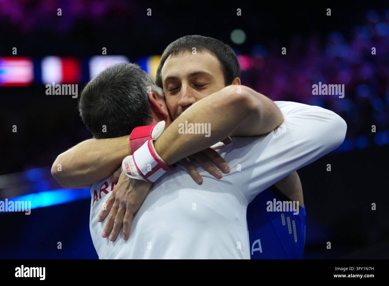 Team Hug Vector Artur Davtyan, of Armenia, hugs his coach after competing in the vault ...