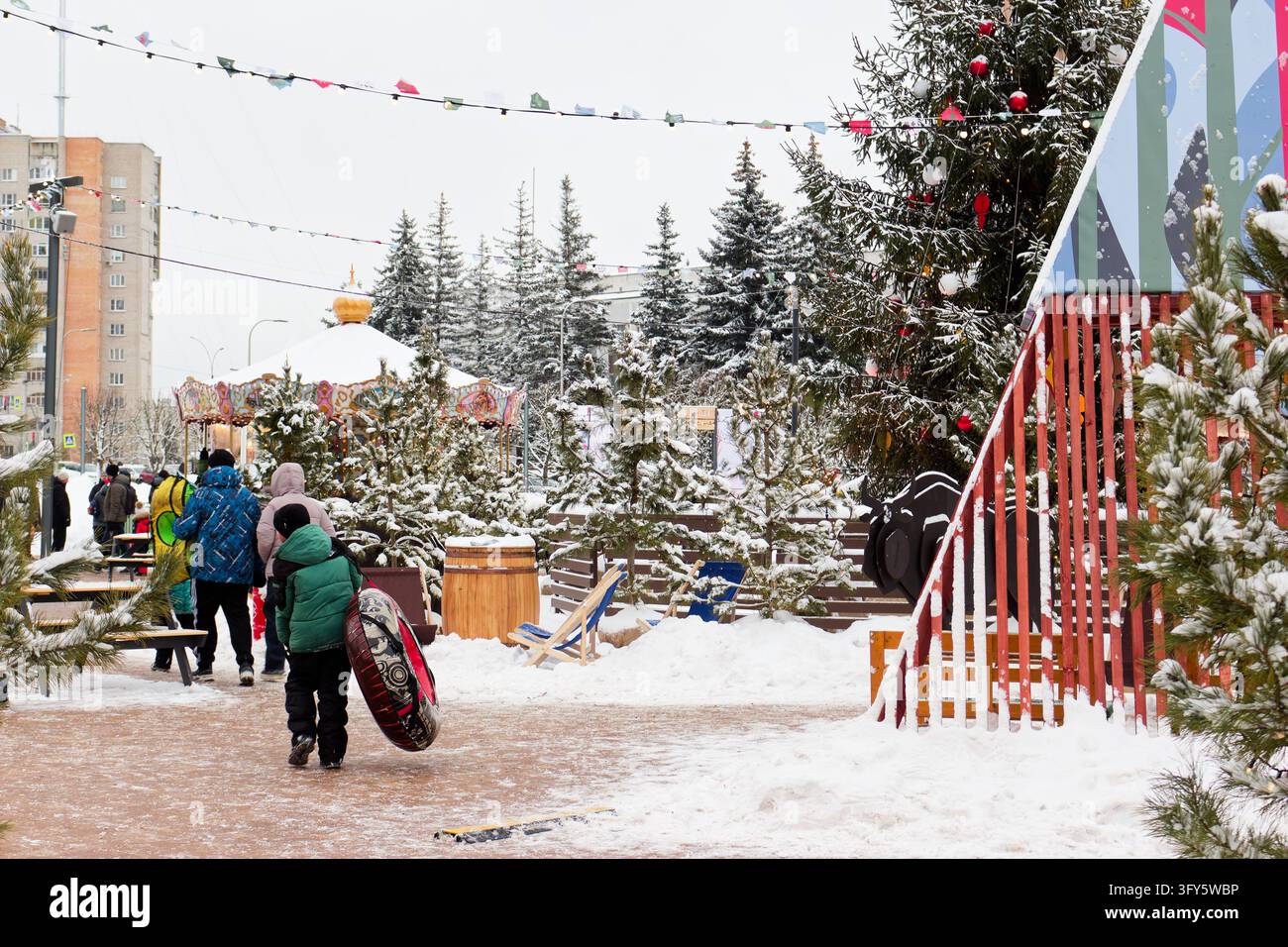Festive Christmas market atmosphere featuring a kid with a snow tube ...