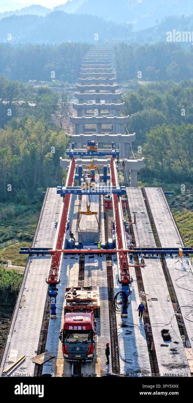 Of Users Builders use a large bridge-erecting machine to install girders at the ...