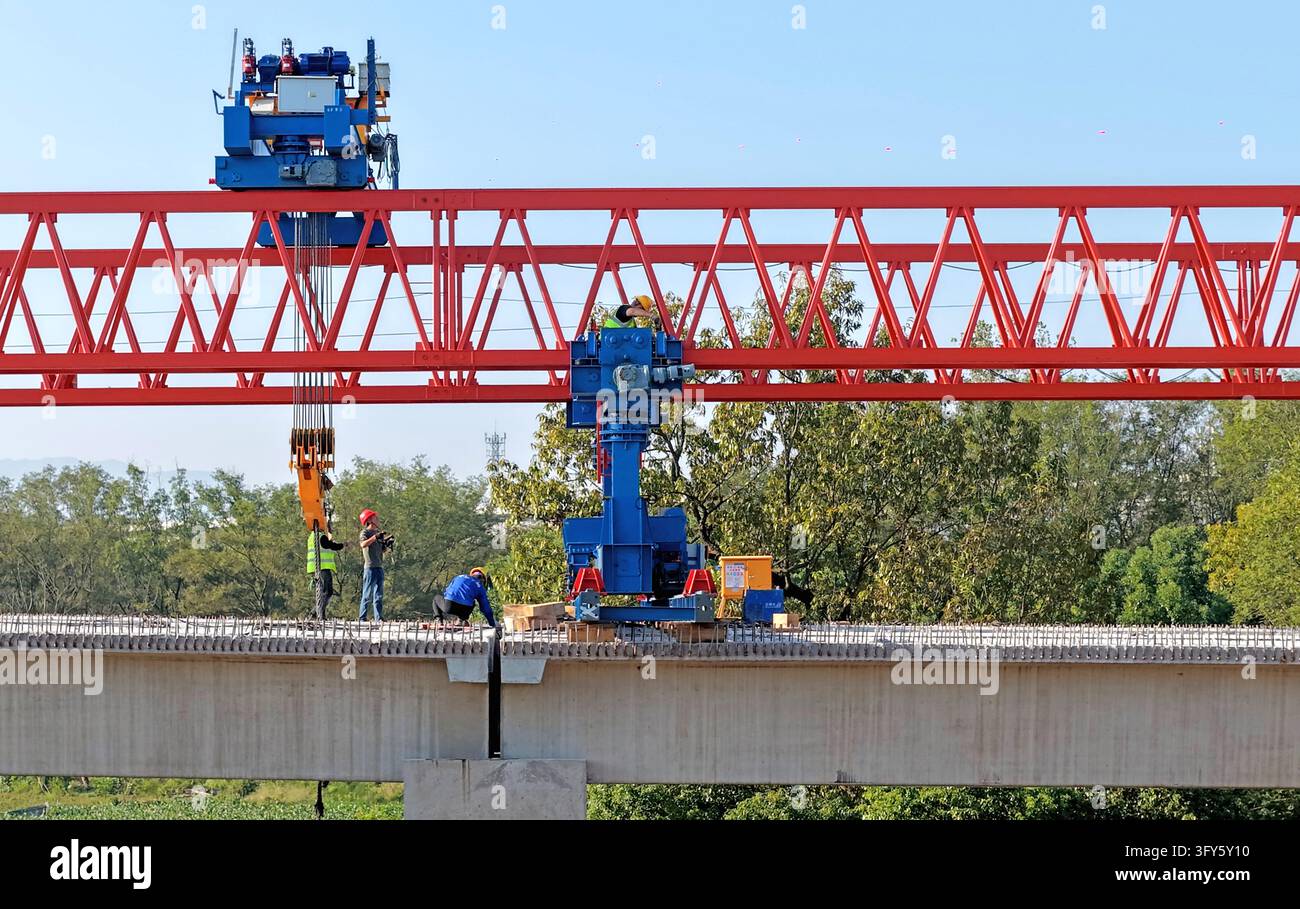 Of Users Builders use a large bridge-erecting machine to install girders at the ...