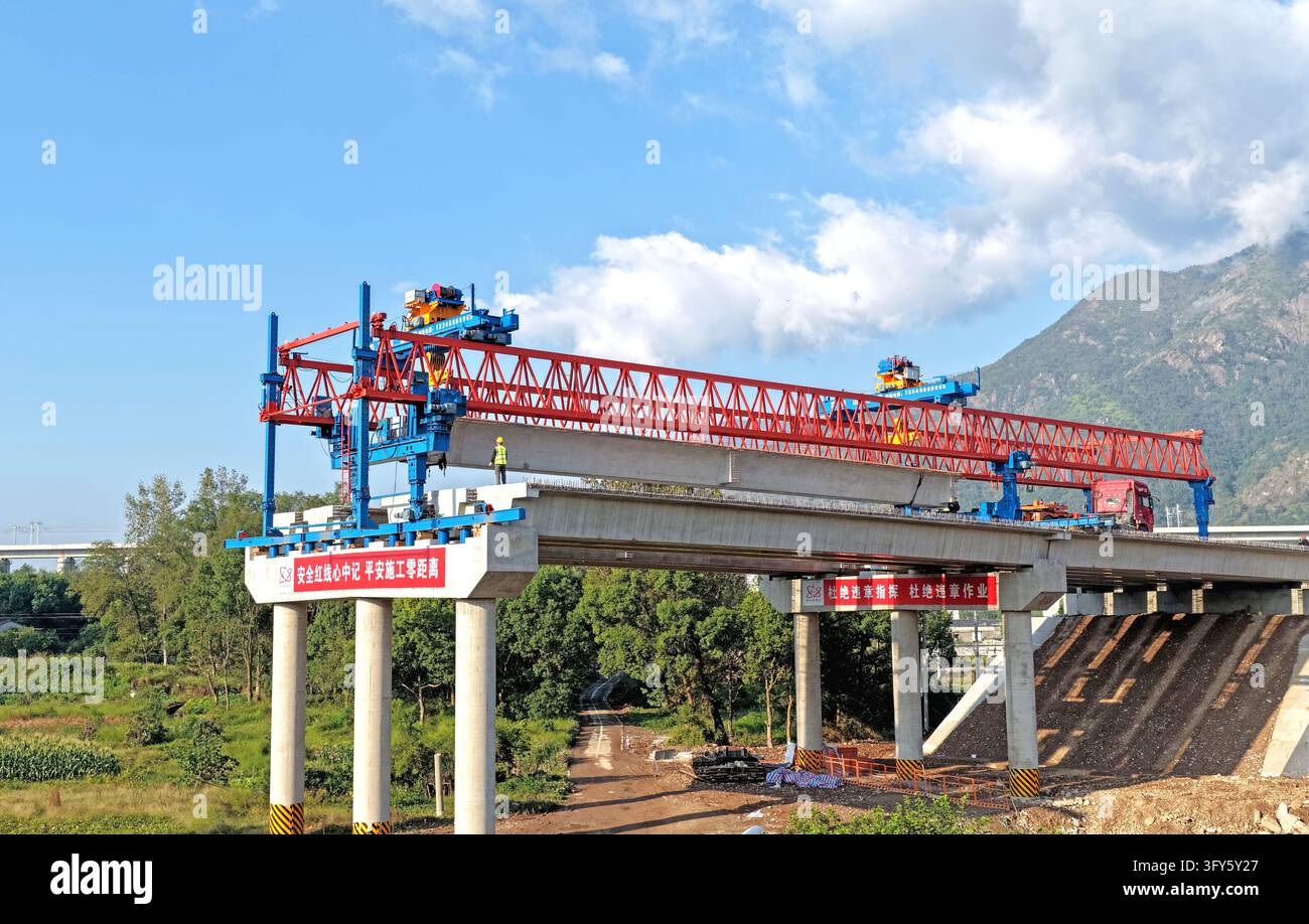 Of Users Builders use a large bridge-erecting machine to install girders at the ...