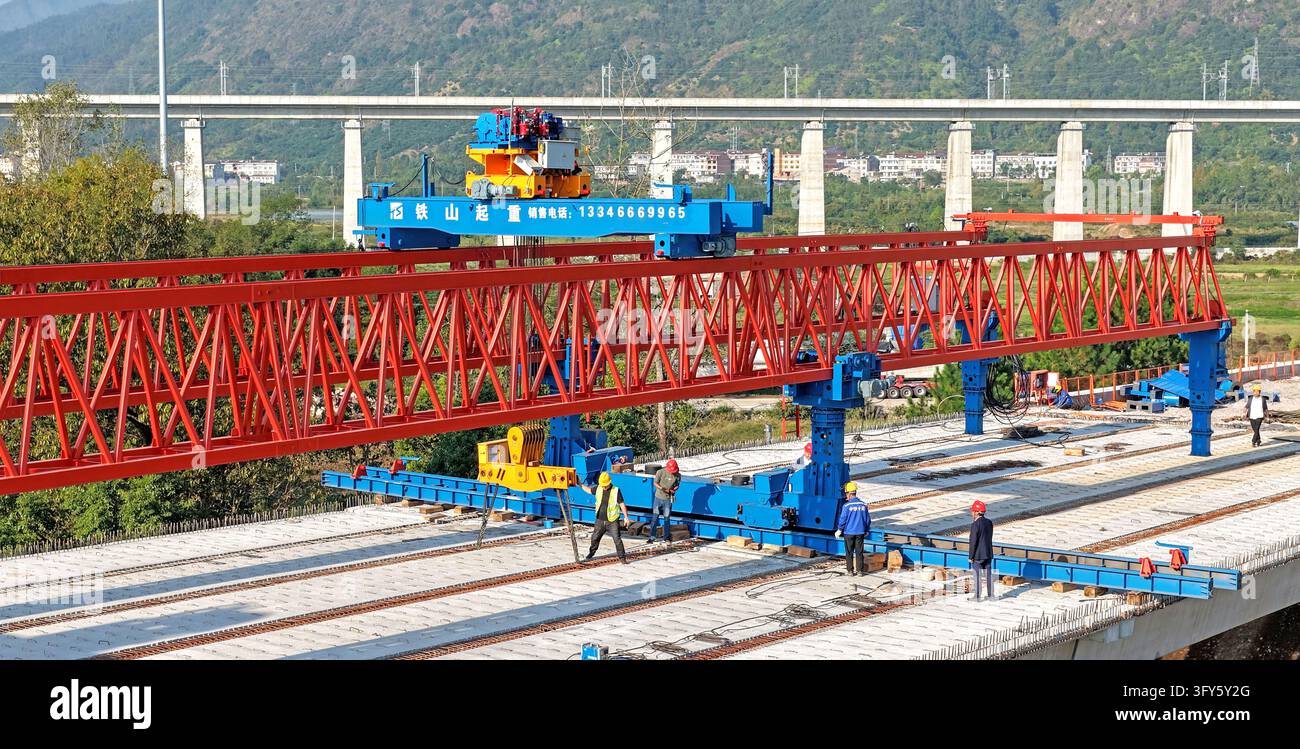 Of Users Builders use a large bridge-erecting machine to install girders at the ...
