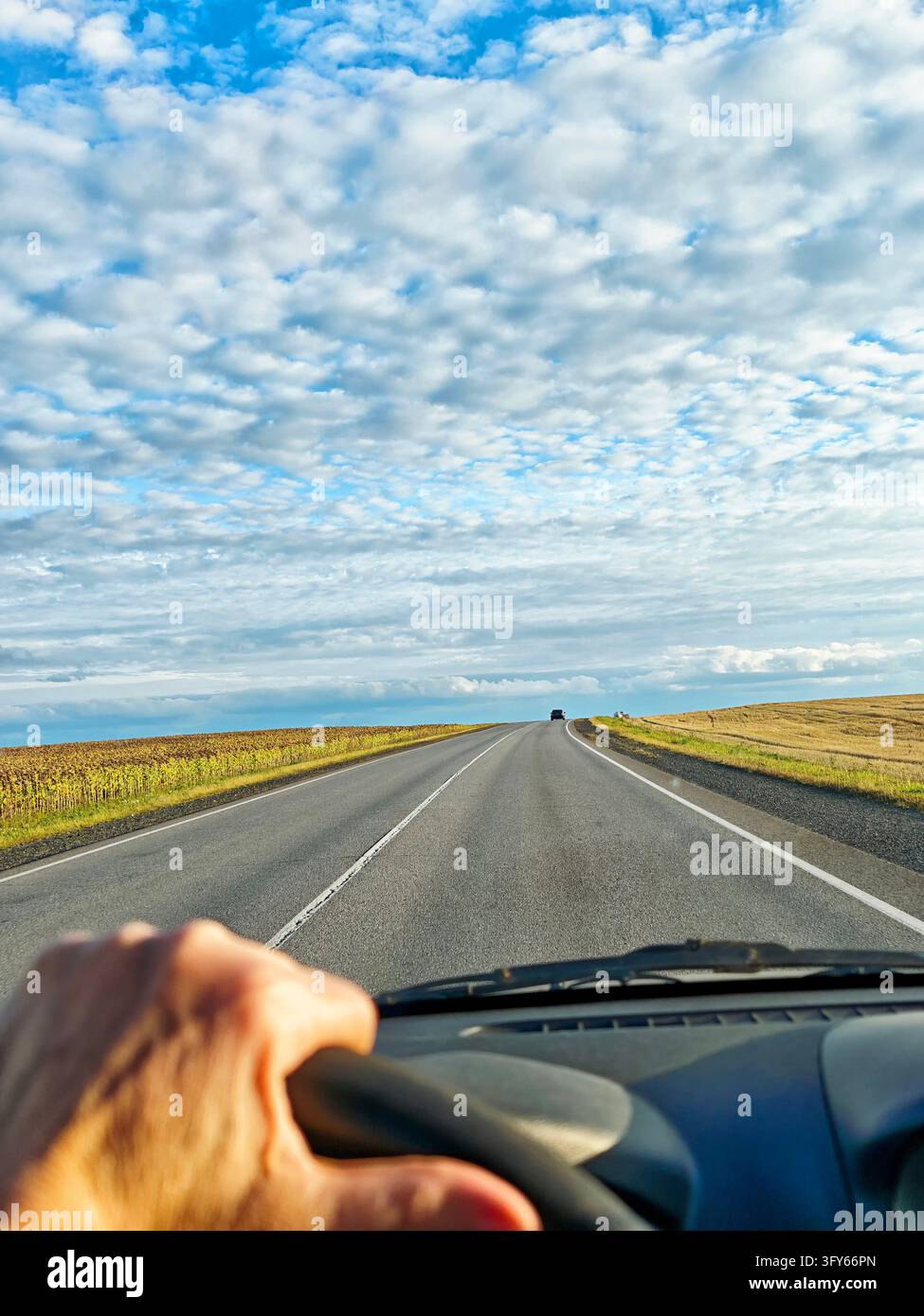 Windshield view: straight country highway stretching toward a distant ...