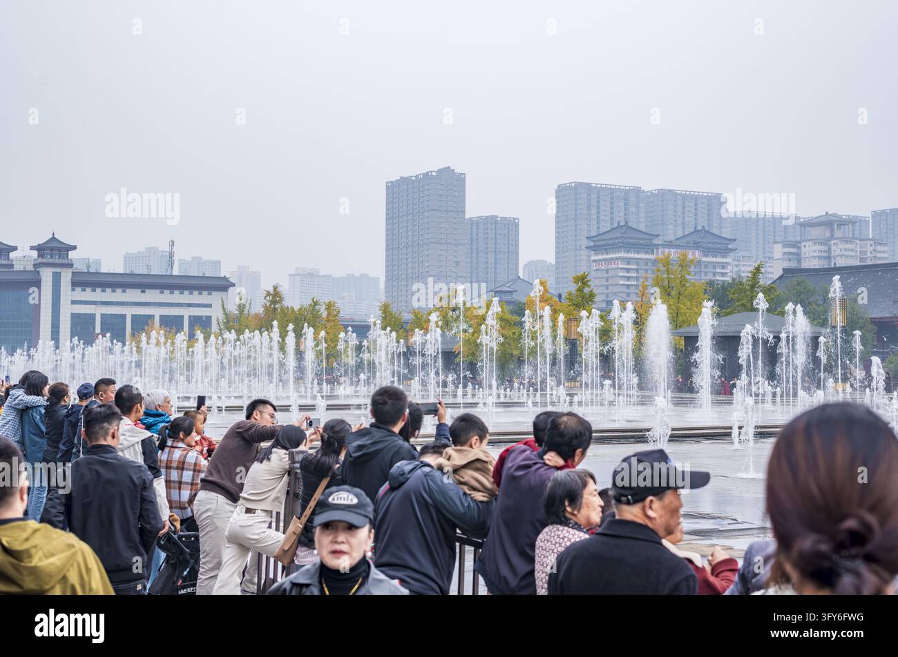 Tourists gather to watch the musical fountain show at the north square ...