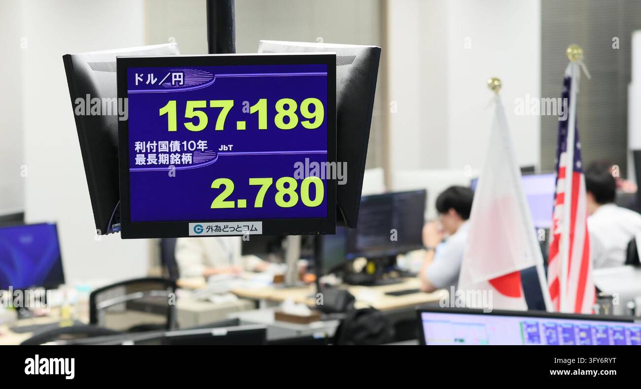A monitor displays Japan's 10-year government bond yield (below) and ...