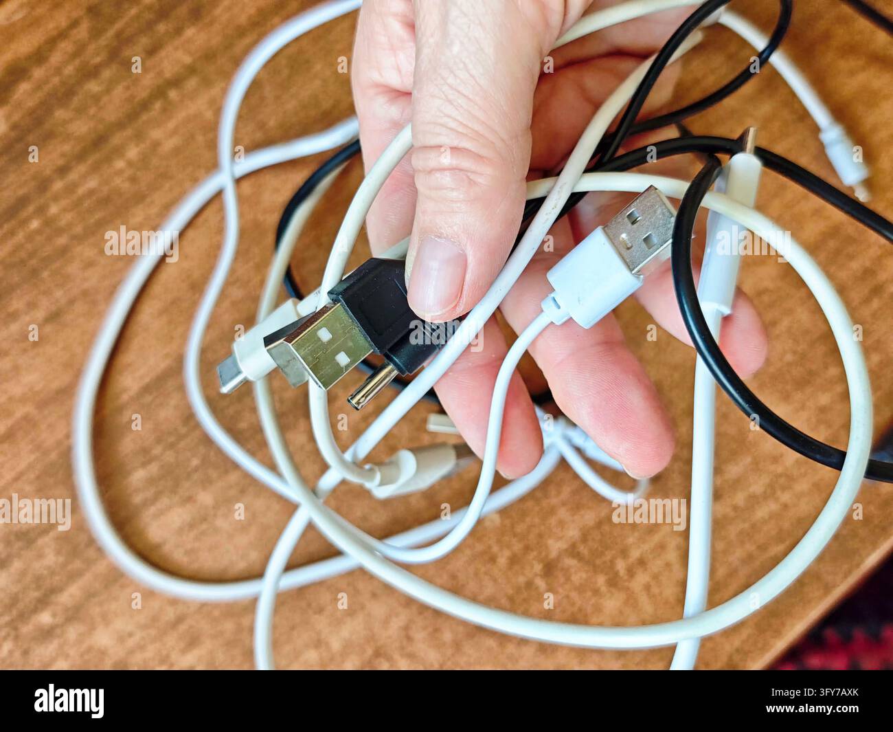 Everyday. Search A hand holds a bundle of tangled white and black charging cables with ...