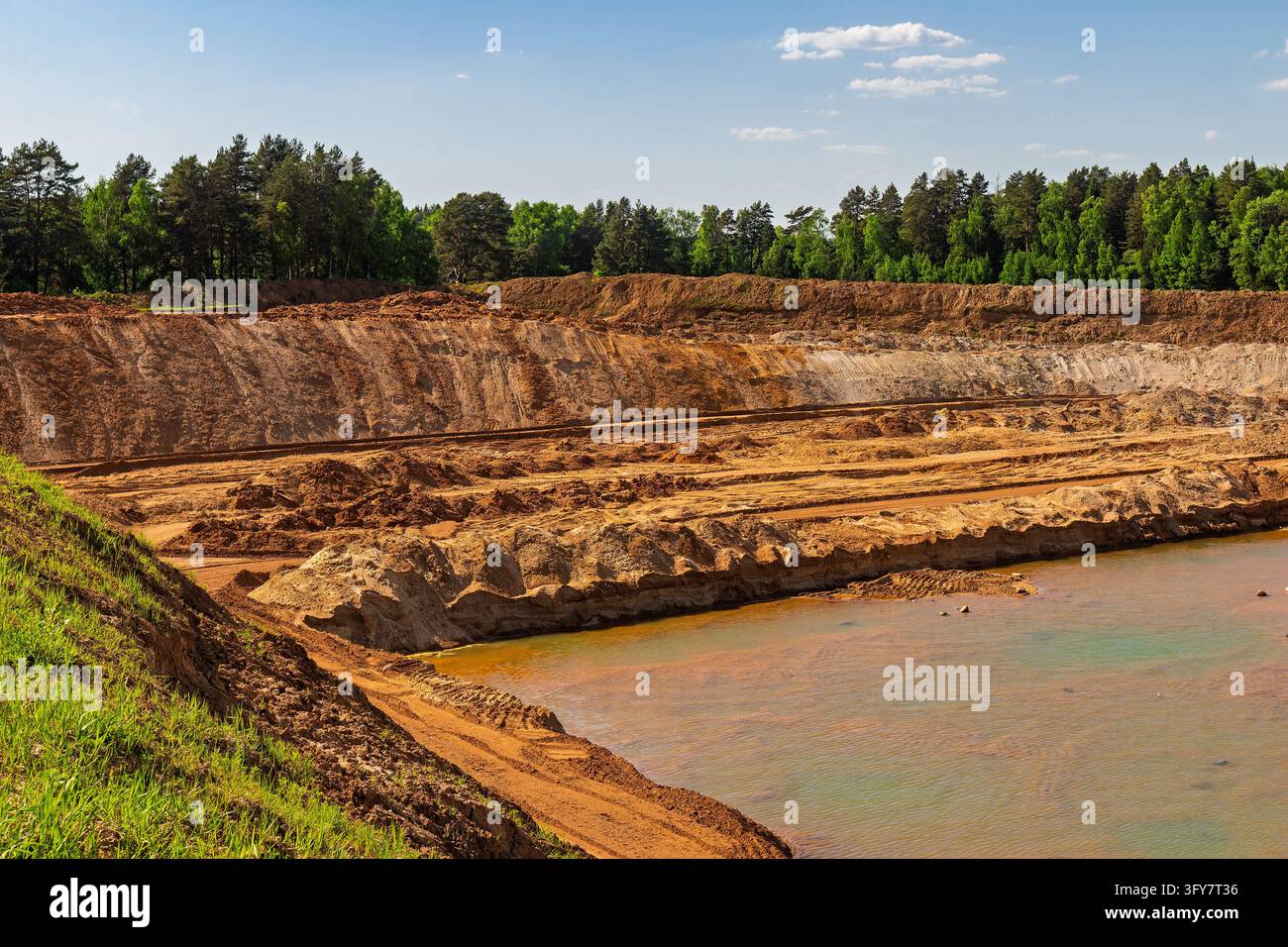 Open-pit sand mining site featuring layered earth strata, excavated ...