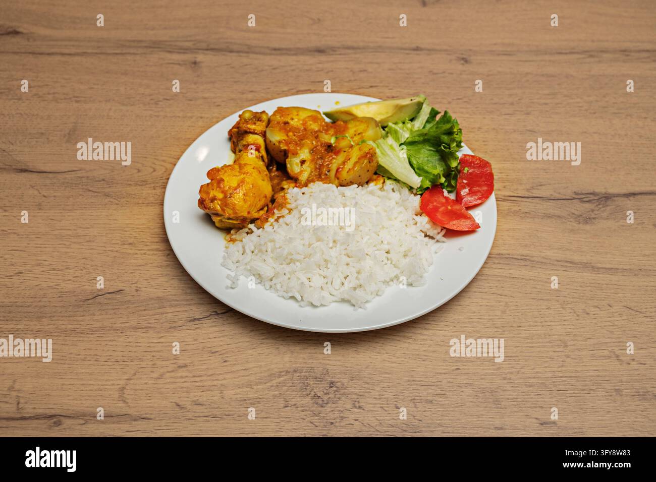 Stewed chicken drumstick in tomato sauce with potatoes, white rice ...