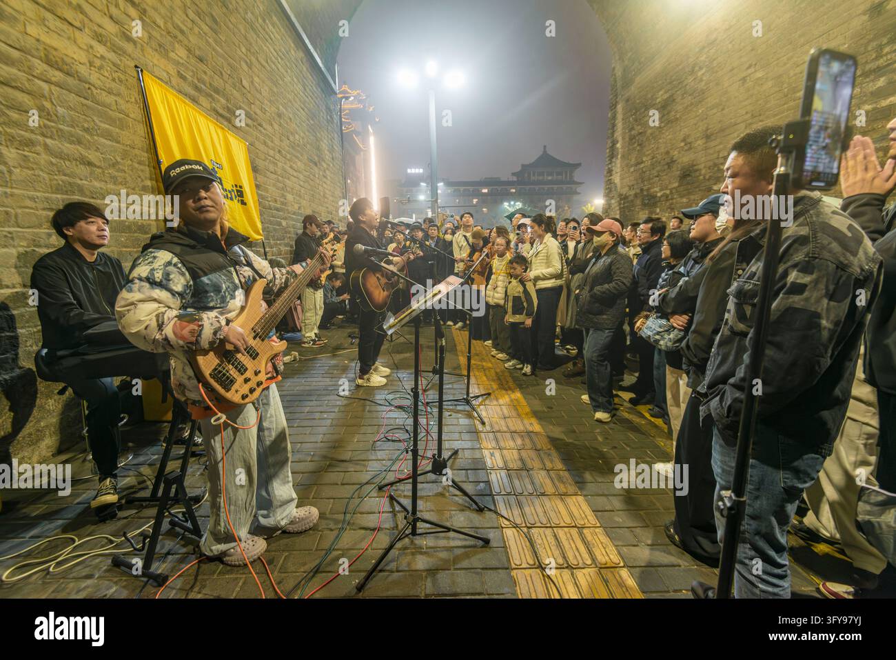 Tourists watch a rock band performing in the park of Yongning Gate, the ...