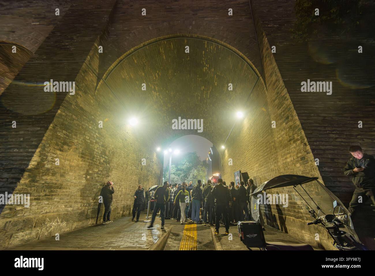 Tourists watch a rock band performing in the park of Yongning Gate, the ...