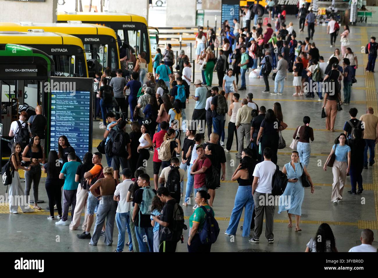 Commuters line up to board buses at the central bus station the day ...