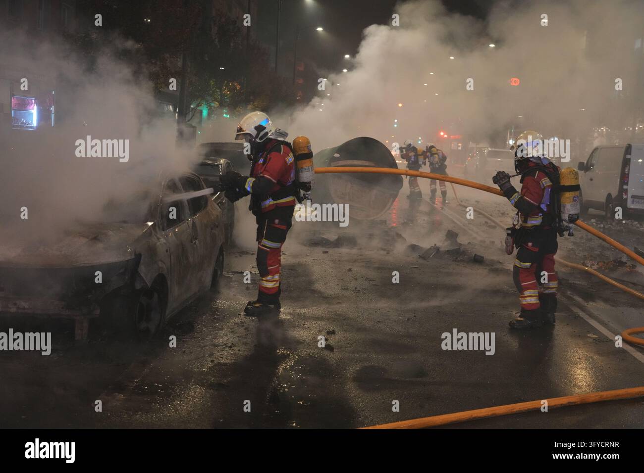 Firefighters put out the fire in the cars following a rally organised ...