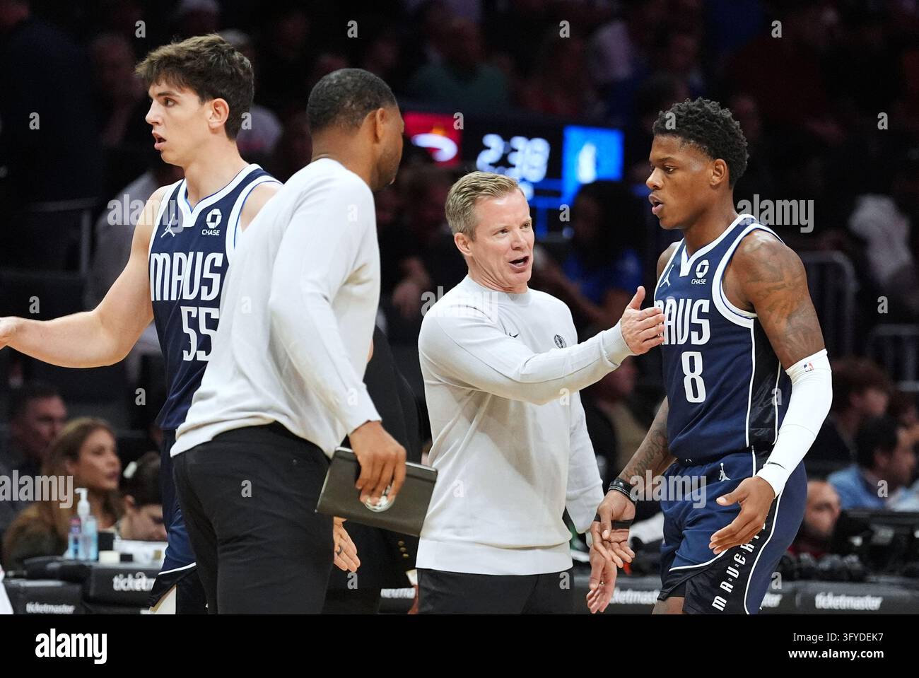 Dallas Mavericks head coach Dusty May, center, talks with guard Marcus ...