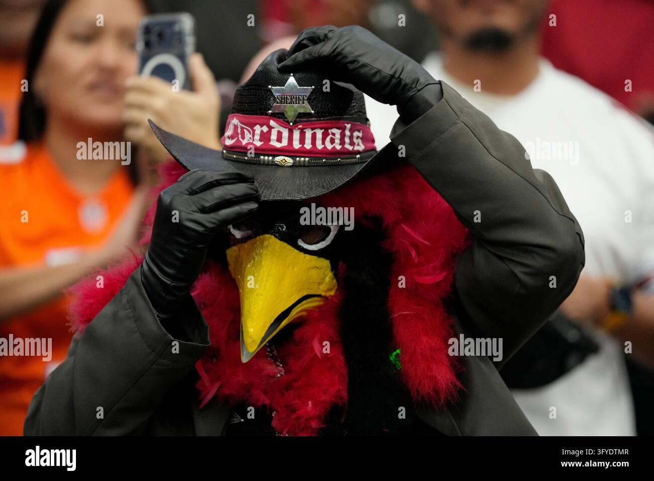 An Arizona Cardinals fan adjusts a cowboy hat prior to an NFL football ...