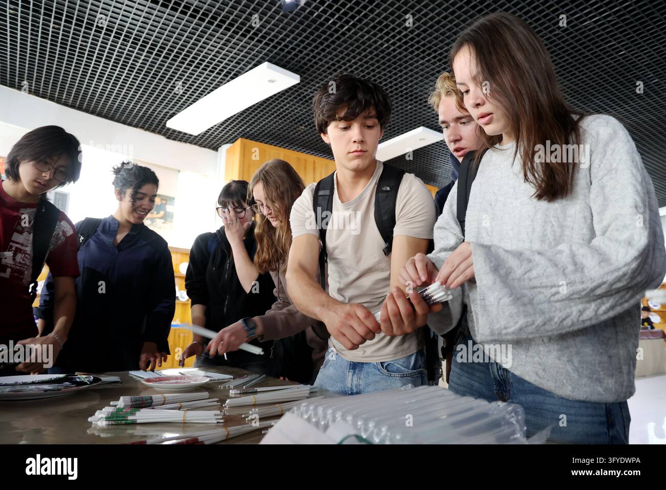French teenagers select shell porcelain chopsticks at the Marine Shell ...