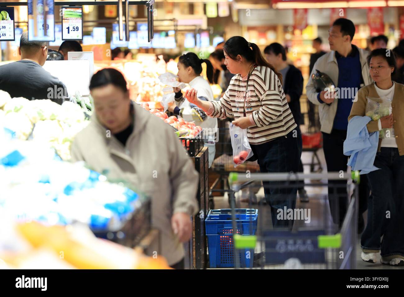A resident shops at a supermarket in Huai'an, east China's Jiangsu ...