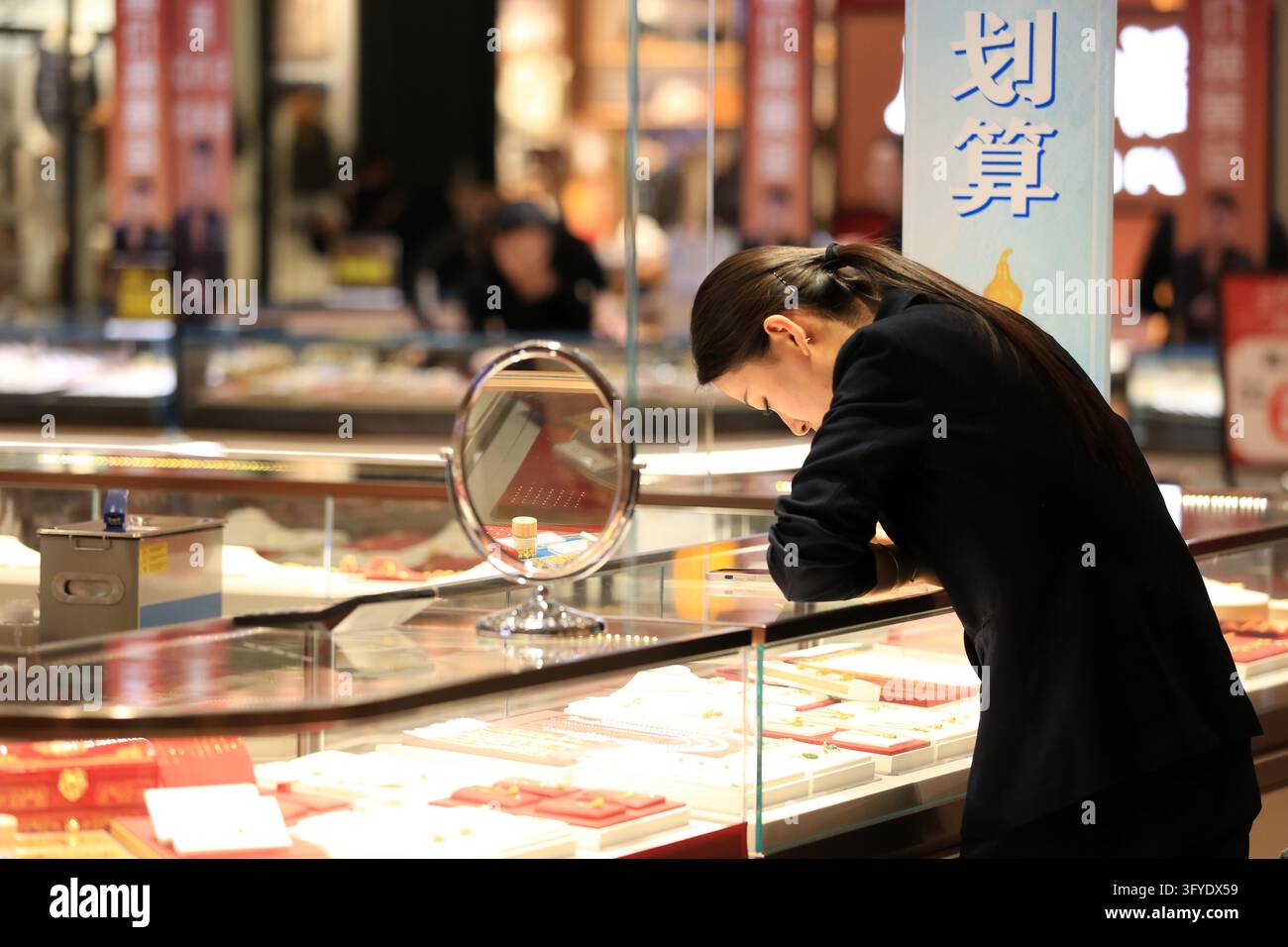 Consumers browse gold jewelry at a store in Huai'an, east China's ...