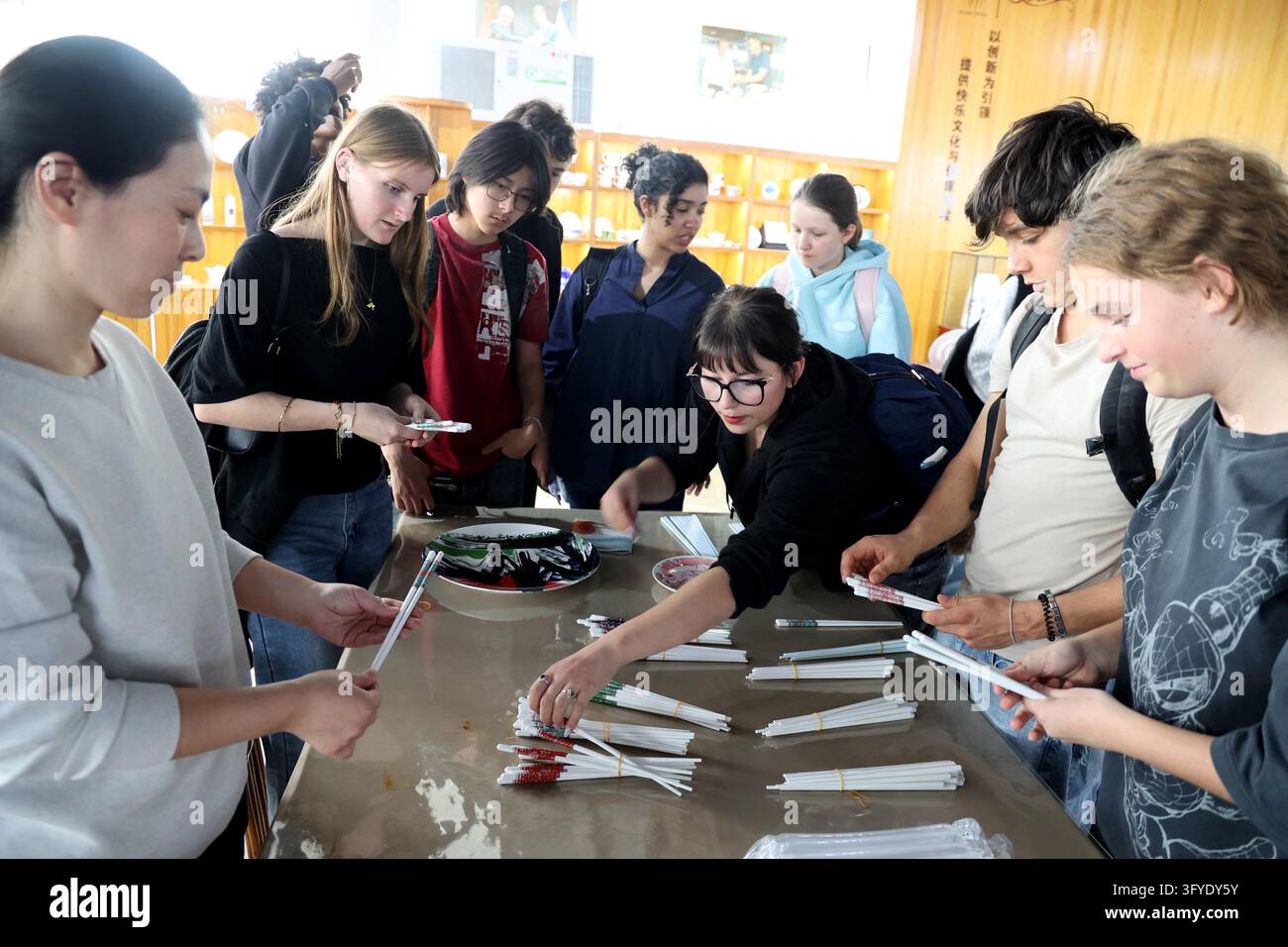 French teenagers select shell porcelain chopsticks at the Marine Shell ...