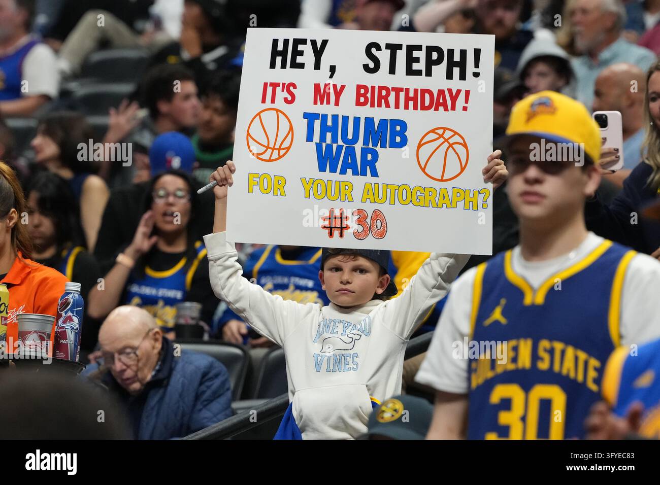 A fan of Golden State Warriors guard Stephen Curry holds up a placard ...