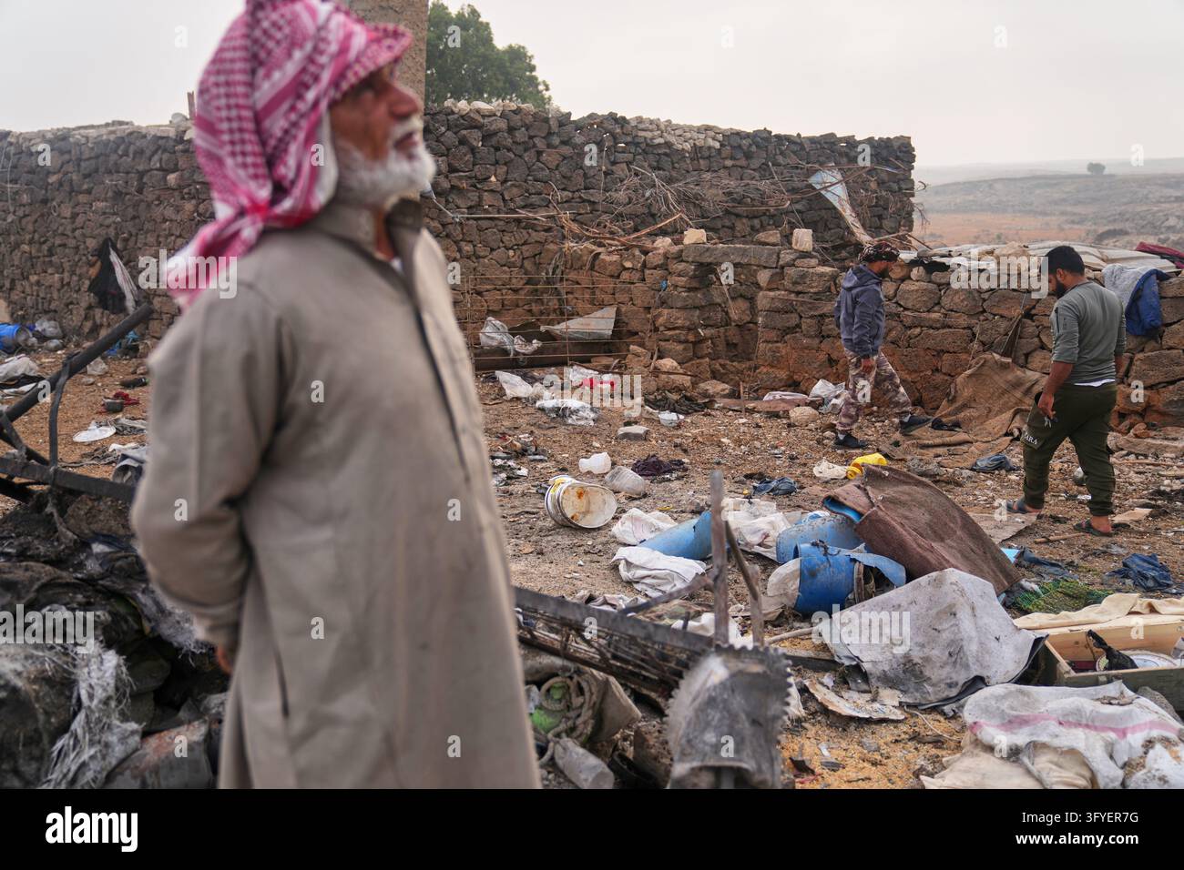 Men inspect the aftermath of a Jordanian airstrike in Lutf, in the ...