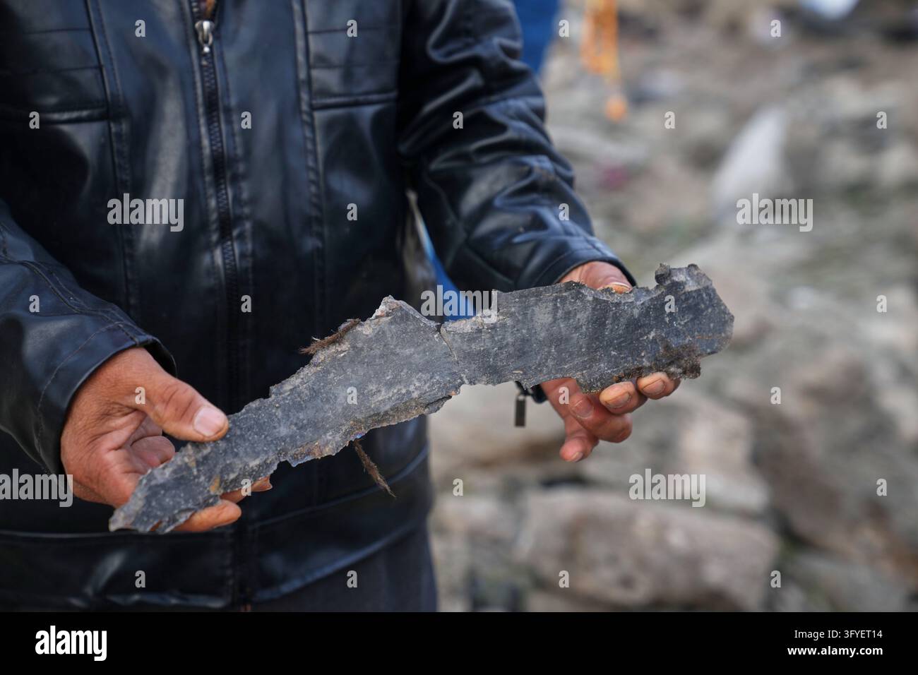 A man holds a piece of debris at the site of a Jordanian airstrike in ...