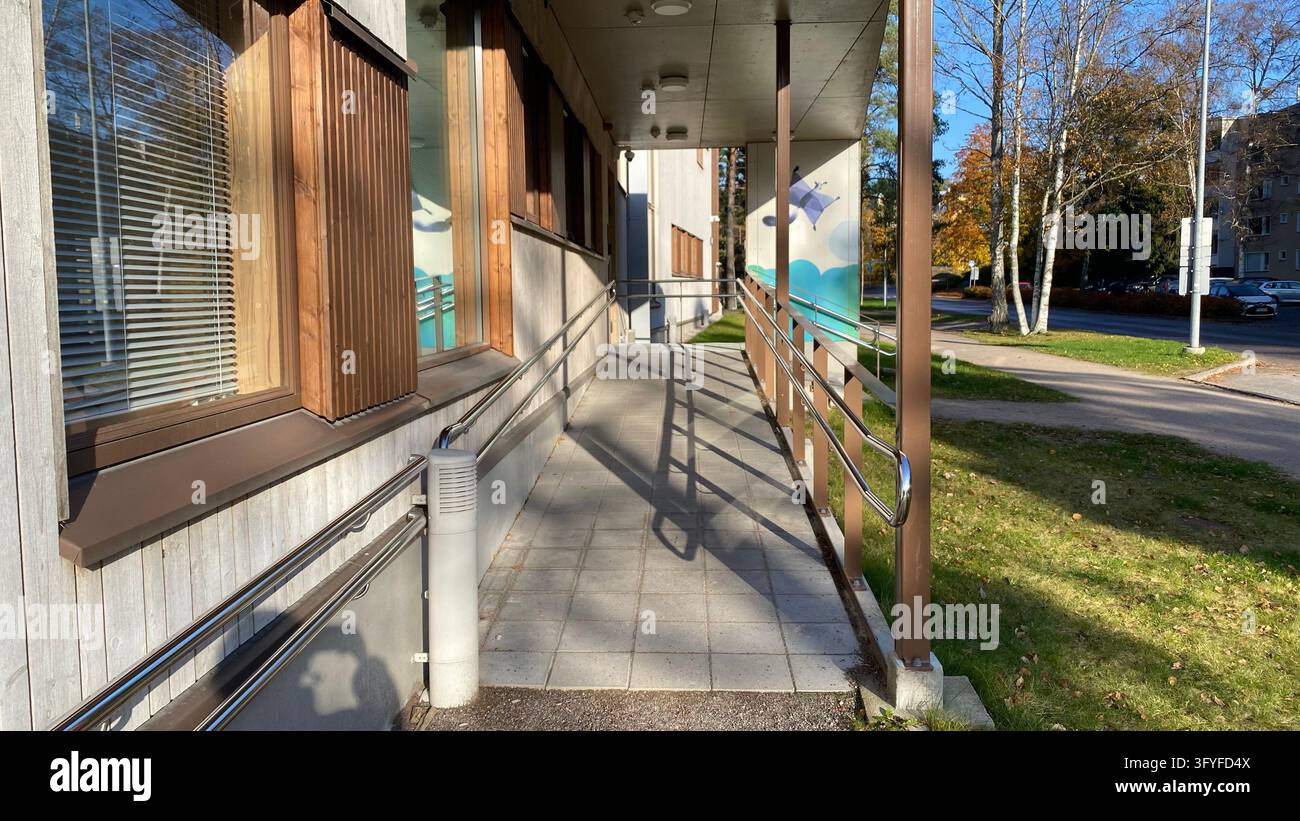 Accessible entrance ramp with metal handrails at modern public building ...