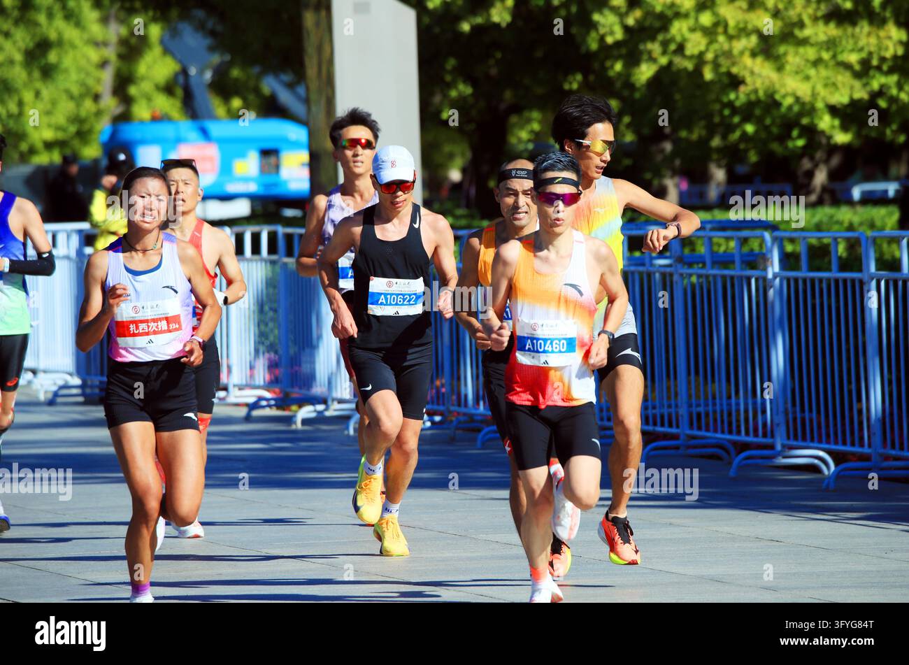 Runners pass a section of road near the Olympic Park during the Beijing ...